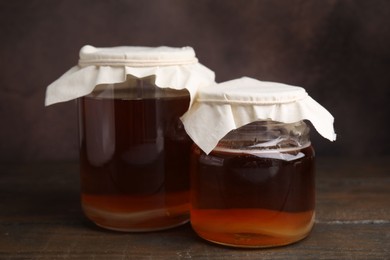 Tasty kombucha in glass jars on wooden table