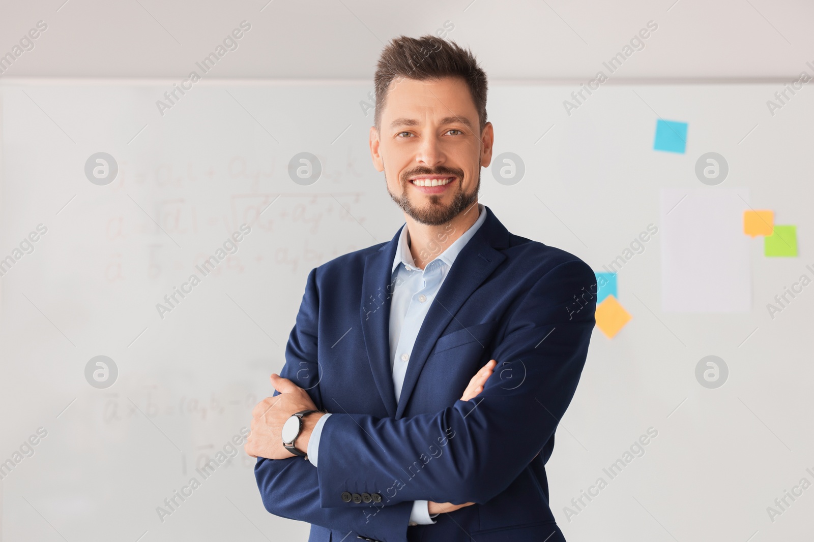 Photo of Happy teacher at whiteboard in classroom during math lesson