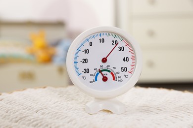 Photo of Round hygrometer with thermometer on mat in room