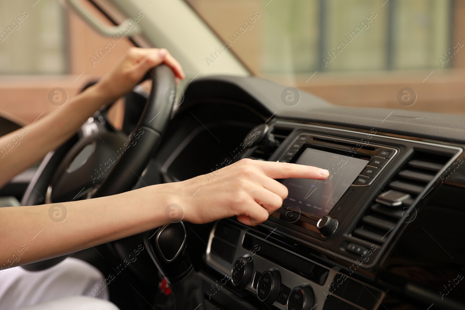 Photo of Woman using navigation system while driving car, closeup