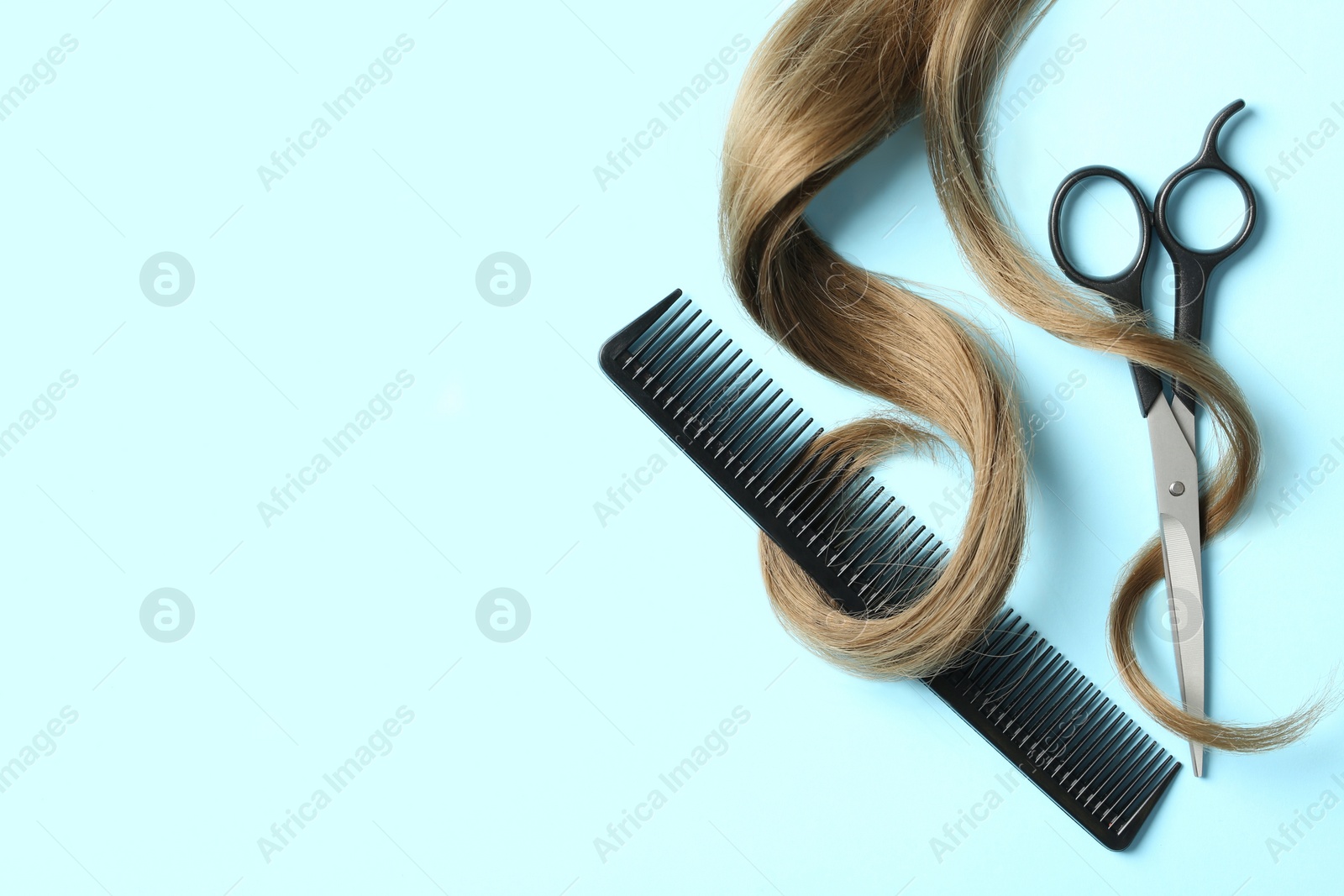 Photo of Flat lay composition with light brown hair, comb, scissors and space for text on color background. Hairdresser service
