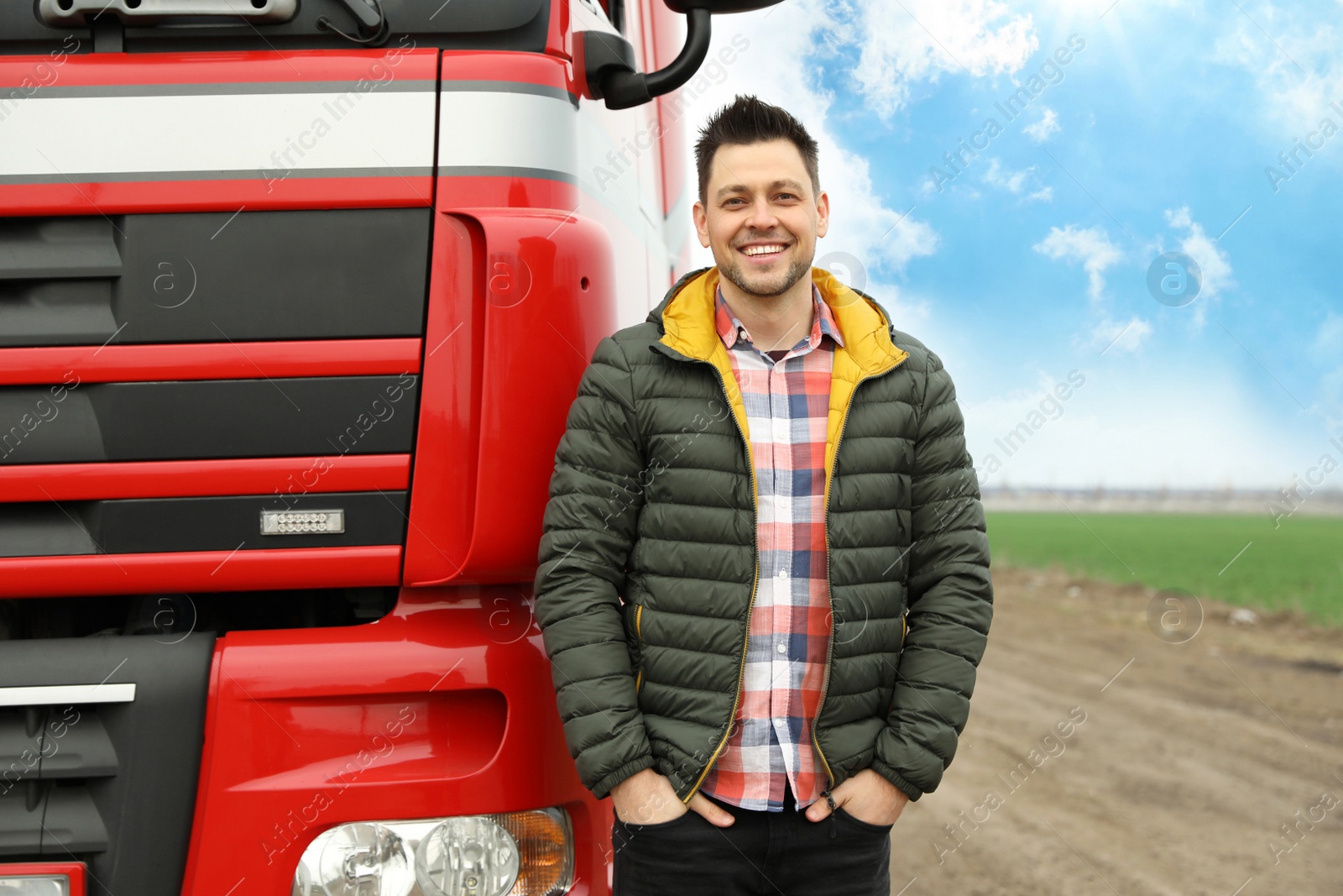 Photo of Portrait of happy driver at modern truck outdoors. Space for text