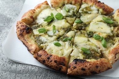 Photo of Delicious pizza with pesto, cheese and basil on grey table, closeup