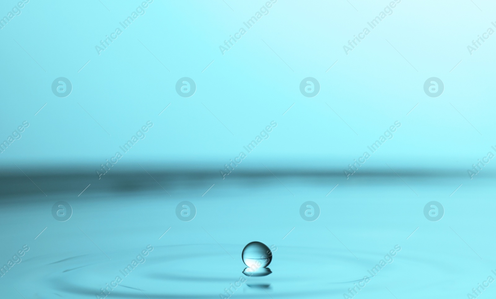 Photo of Splash of clear water with drop on turquoise background, closeup