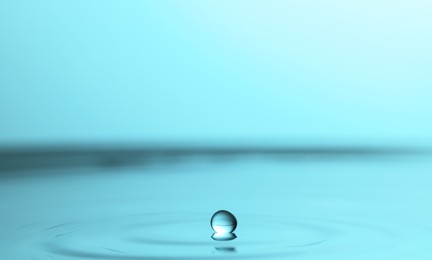 Photo of Splash of clear water with drop on turquoise background, closeup