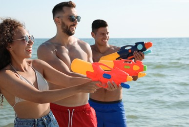 Friends with water guns having fun near sea