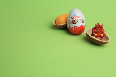 Photo of Sveti Vlas, Bulgaria - July 3, 2023: Kinder Surprise Eggs, plastic capsule and toy on green background, space for text
