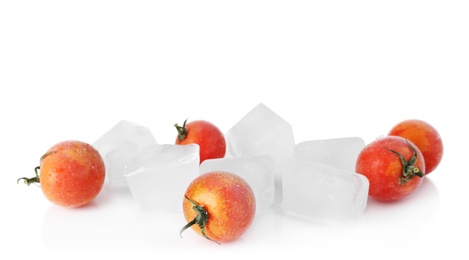 Photo of Frozen cherry tomatoes and ice cubes on white background. Keeping vegetables fresh