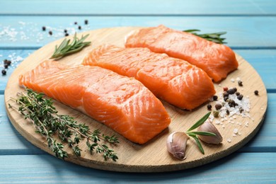 Photo of Fresh raw salmon and ingredients for marinade on light blue wooden table, closeup