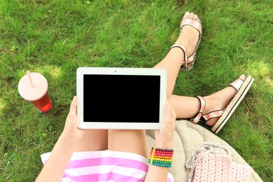 Photo of Woman holding tablet with blank screen outdoors. Mockup for design