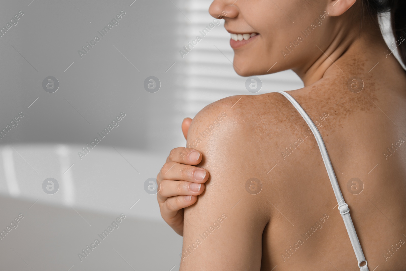Photo of Young woman with smooth skin in bathroom, closeup and space for text. Body care