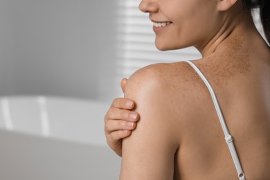 Photo of Young woman with smooth skin in bathroom, closeup and space for text. Body care