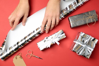 Photo of Woman decorating gift box on color background, top view