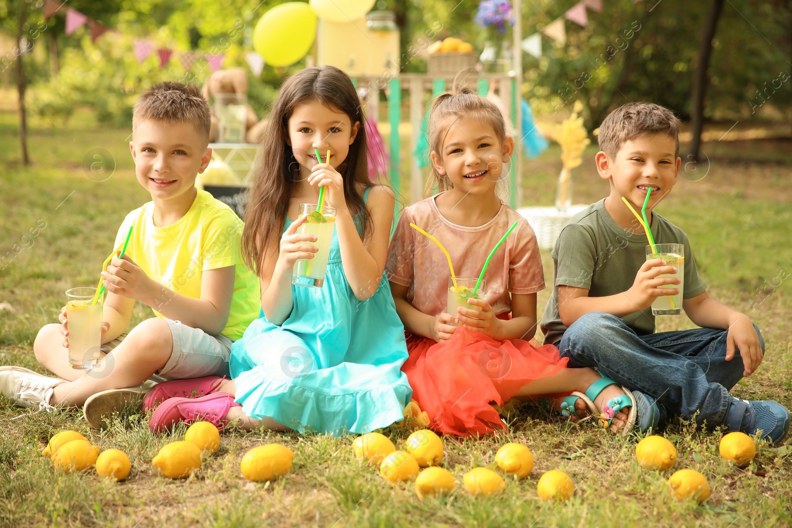 Photo of Little children with natural lemonade in park