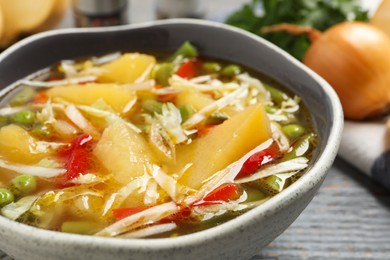 Photo of Bowl of delicious turnip soup on grey table, closeup