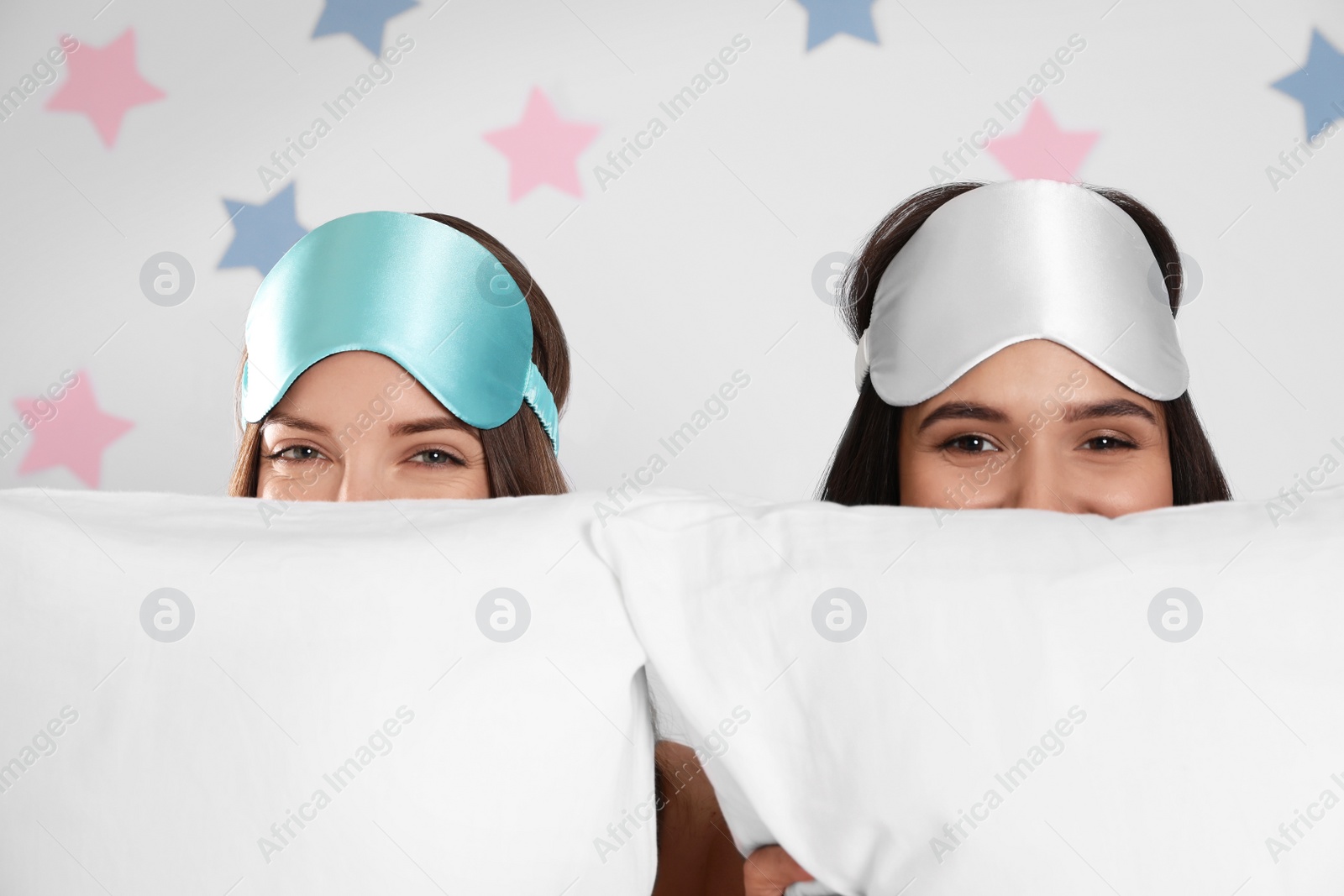 Photo of Beautiful women with pillows on light grey  background. Bedtime