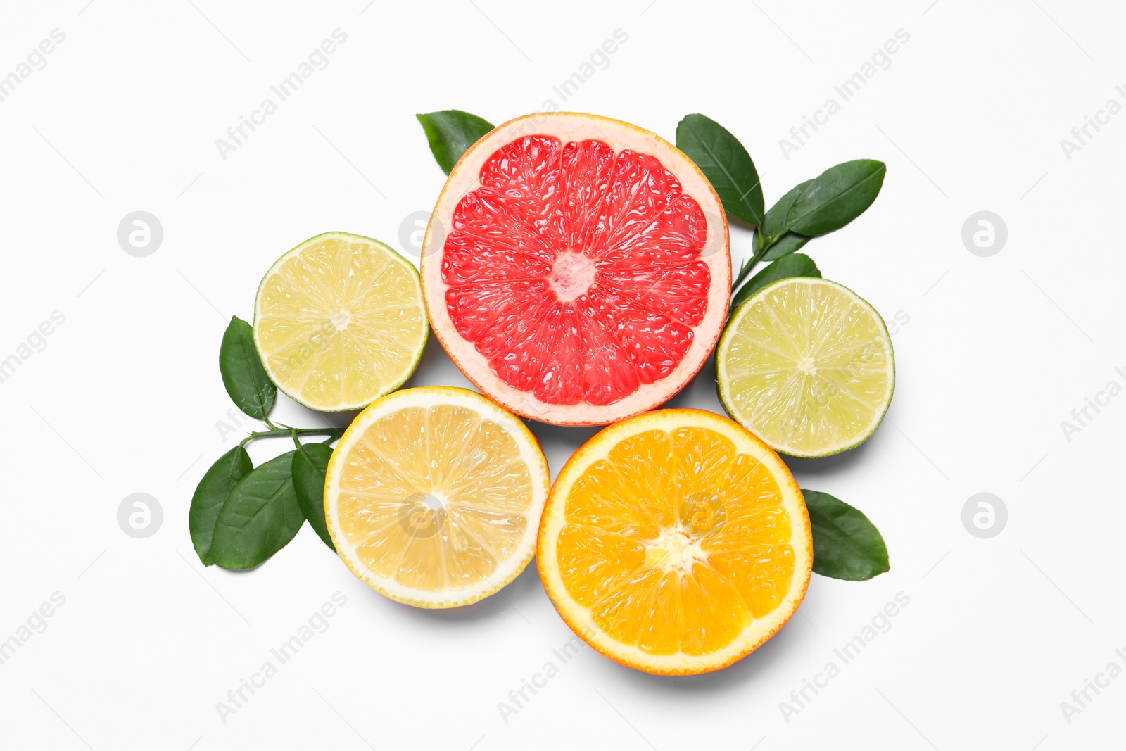 Photo of Different cut citrus fruits and leaves on white table, flat lay