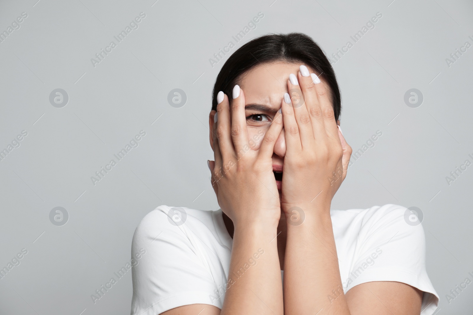 Photo of Young woman feeling fear on grey background