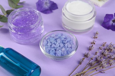 Photo of Homemade cosmetic products and fresh ingredients on violet background, closeup