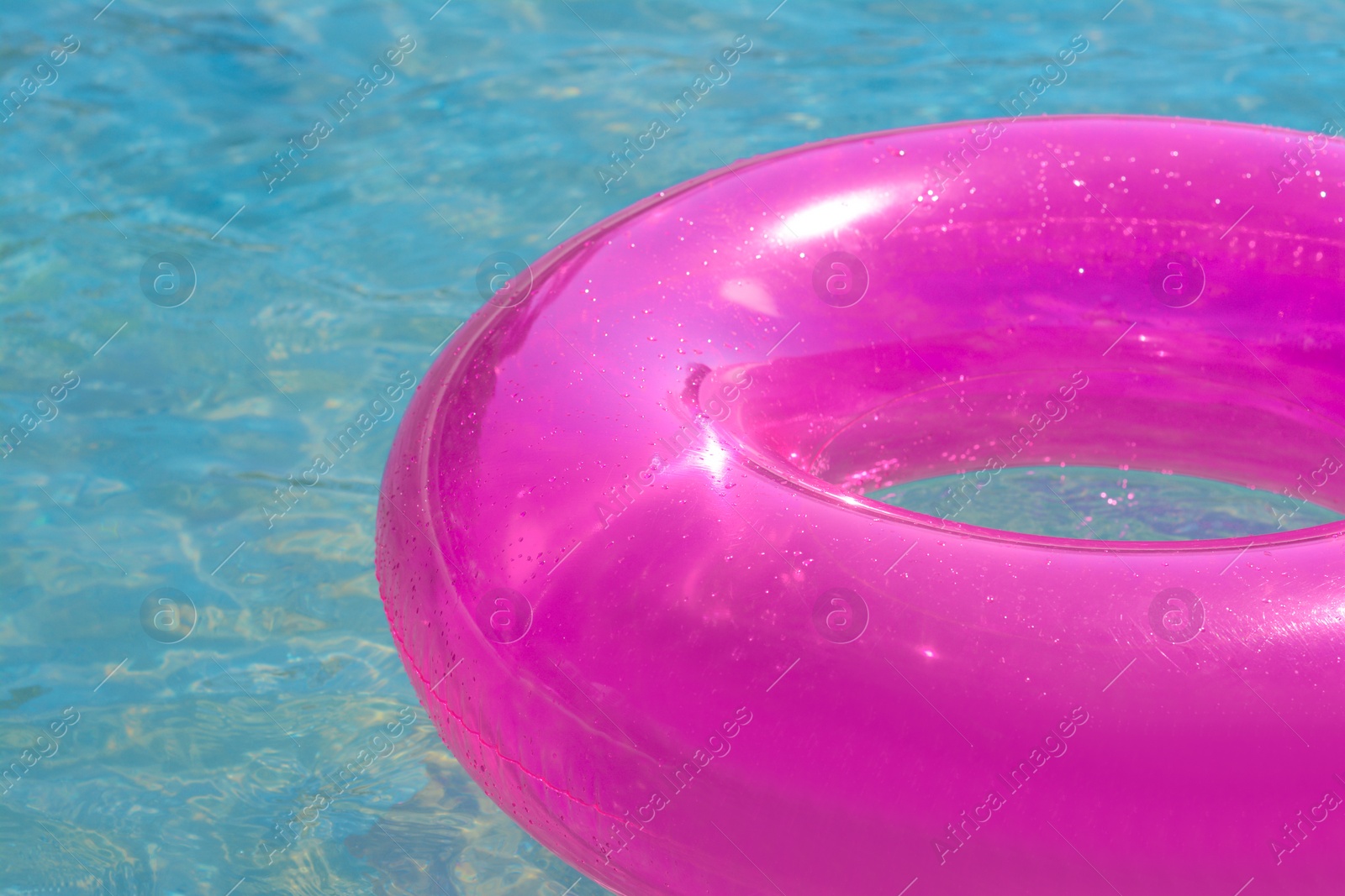 Photo of Bright inflatable ring floating on sea water, closeup