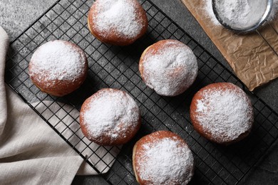 Delicious sweet buns, powdered sugar and strainer on table, flat lay