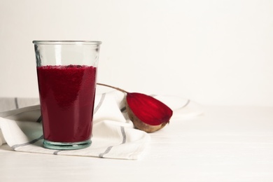 Glass of tasty beet smoothie on table. Space for text