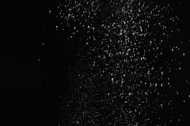 Photo of Snow flakes falling on black background. Winter weather