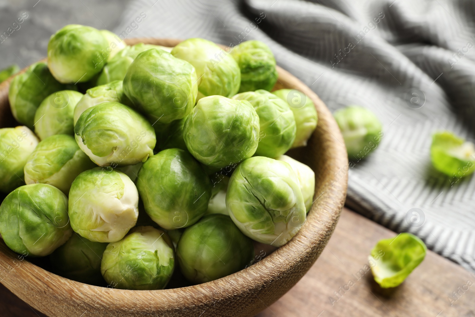 Photo of Bowl of Brussels sprouts on table, closeup. Space for text