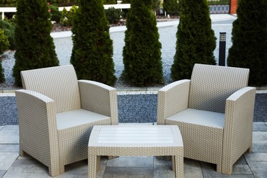Comfortable armchairs and coffee table outdoors. Beautiful rattan garden furniture