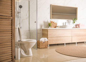 Elegant modern bathroom with wooden cabinet near marble wall