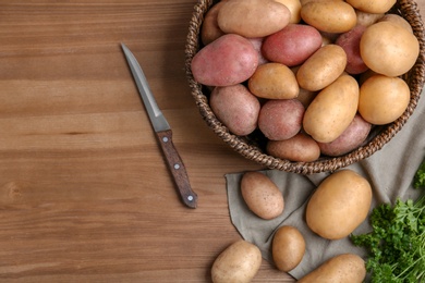 Flat lay composition with fresh organic potatoes and space for text on wooden background