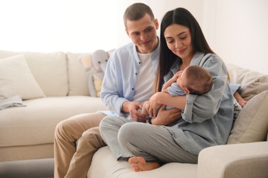 Photo of Happy family with cute baby on sofa at home