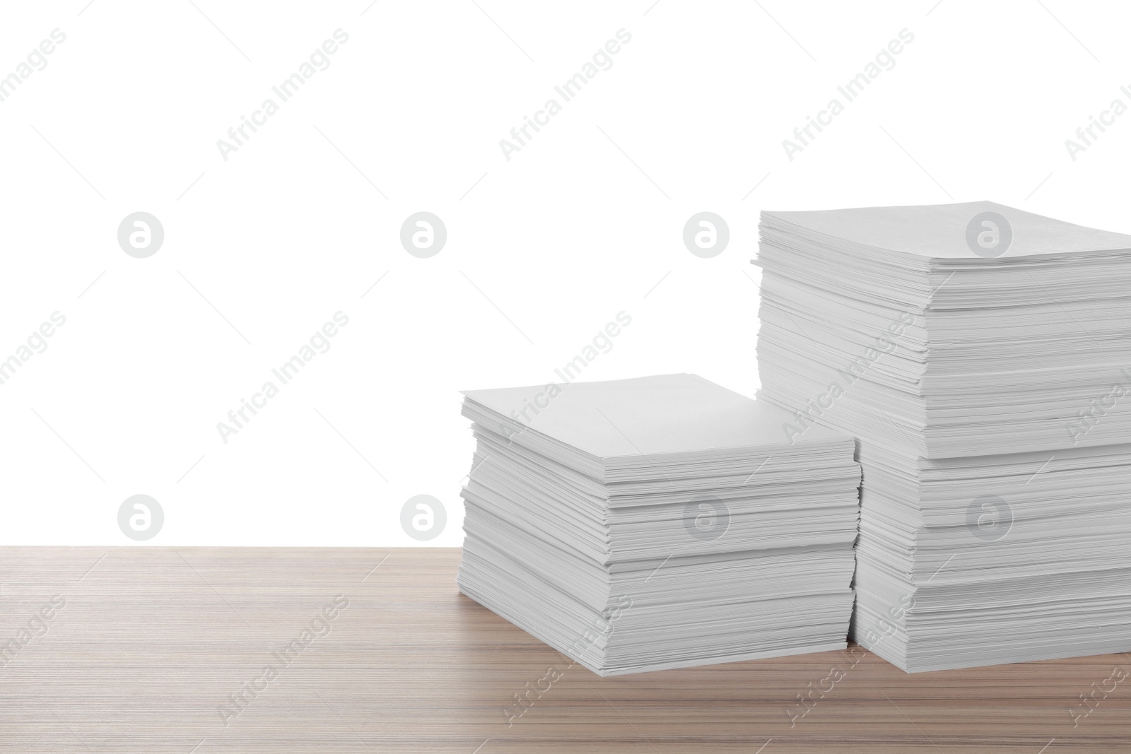 Photo of Stacks of paper sheets on wooden table against white background. Space for text