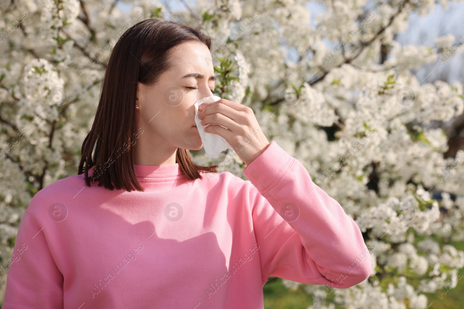 Photo of Woman with napkin suffering from seasonal allergy on spring day