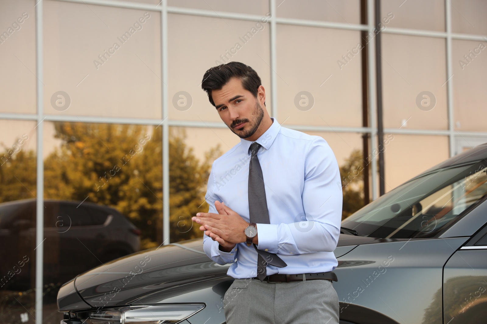 Photo of Attractive young man near luxury car outdoors