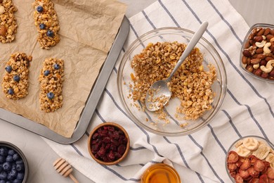 Photo of Making granola bars. Baking tray and ingredients on light grey table, flat lay