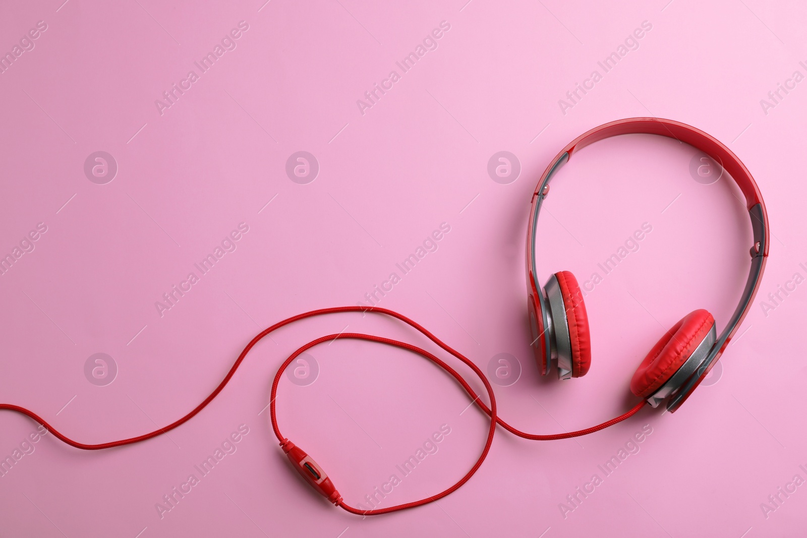 Photo of Stylish headphones on color background, top view. Space for text