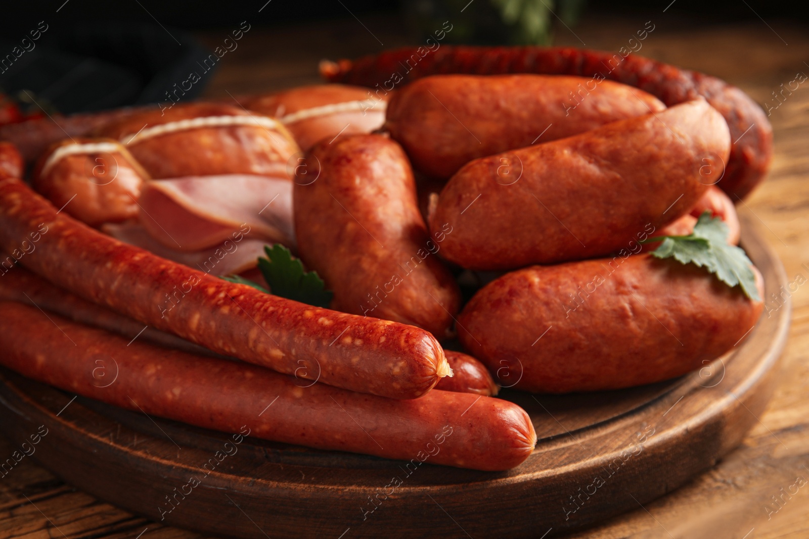 Photo of Different tasty sausages on wooden table, closeup