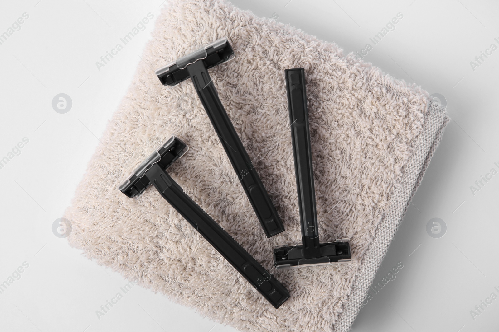 Photo of Razors and towel on white background, top view