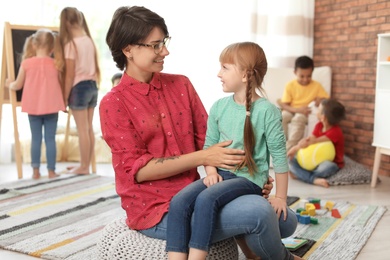 Young woman with little child indoors. Learning by playing