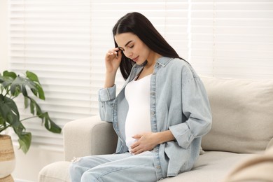 Photo of Pregnant young woman on sofa at home