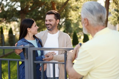 Photo of Friendly relationship with neighbours. Happy couple and senior man near fence outdoors