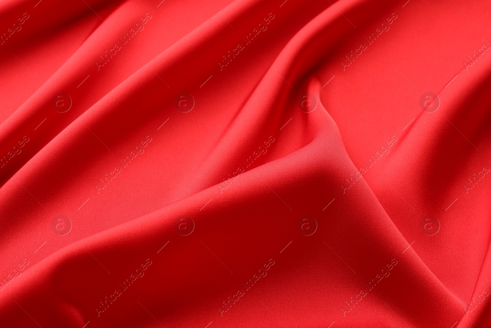 Photo of Crumpled red silk fabric as background, closeup