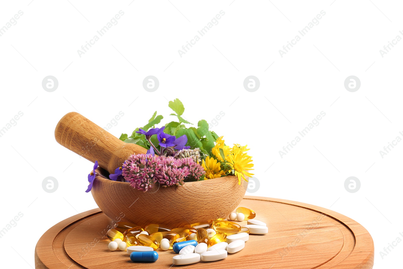 Photo of Board with mortar, fresh herbs and pills on white background