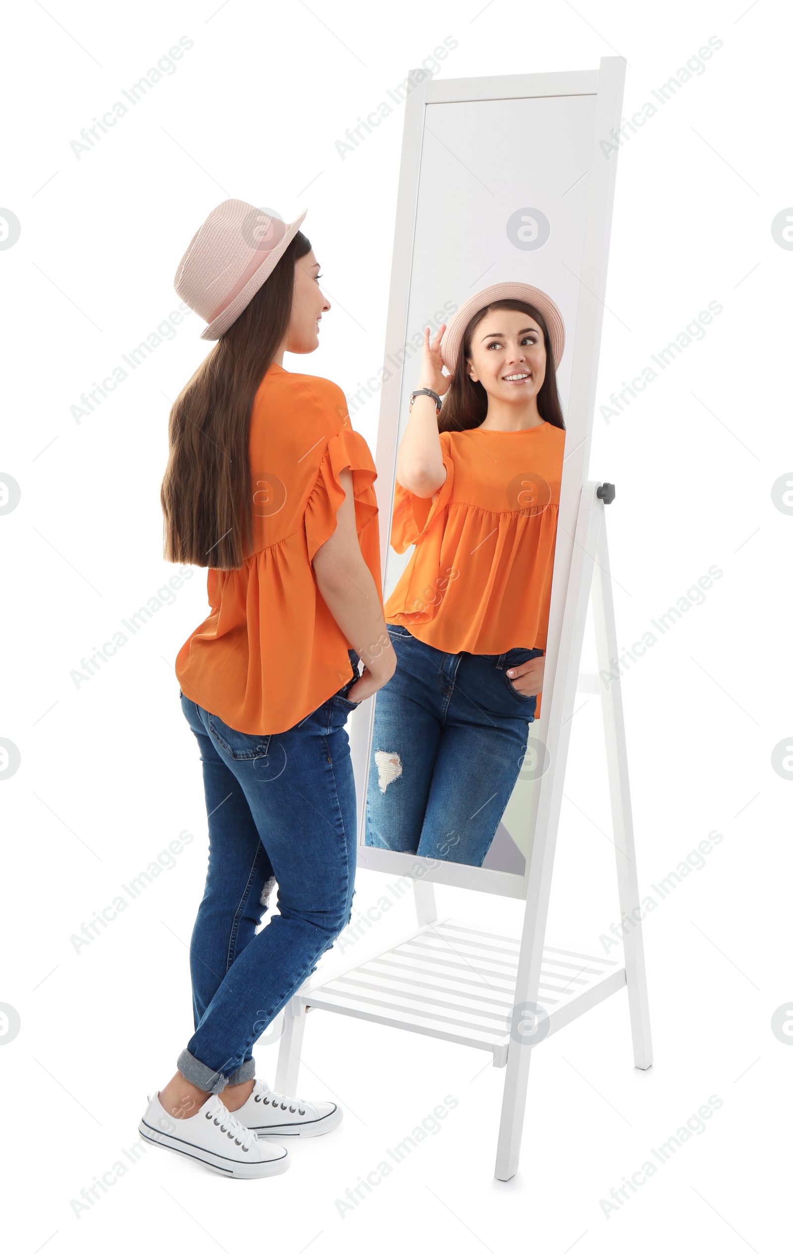 Photo of Young woman looking at her reflection in mirror on white background