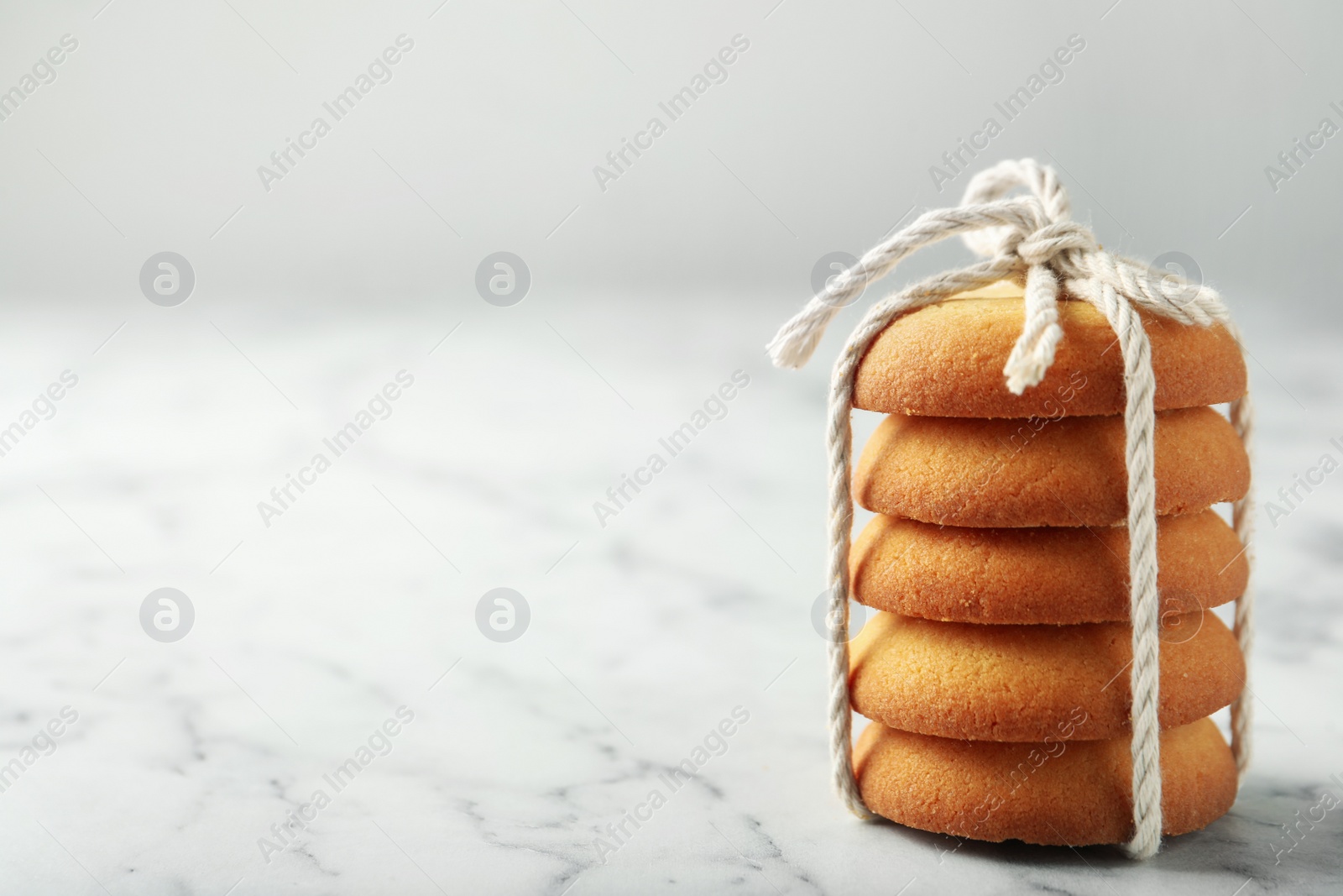 Photo of Tasty shortbread cookies on marble table, space for text