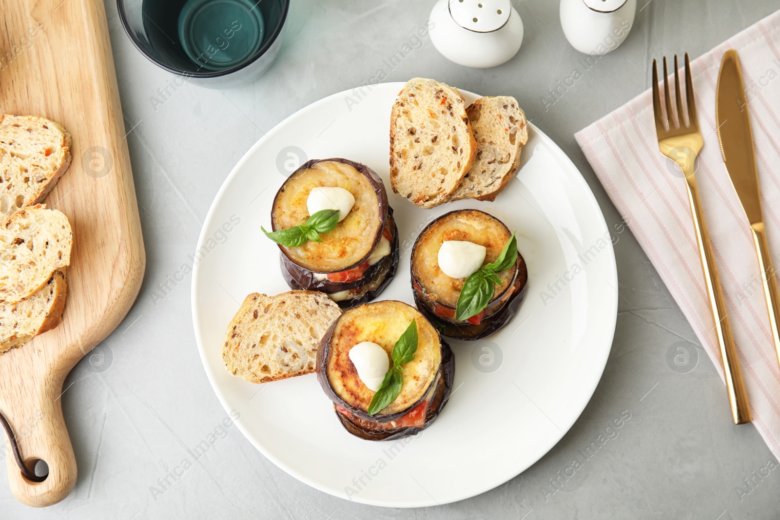 Photo of Baked eggplant with tomatoes, cheese and basil served on light table, flat lay