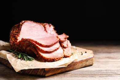 Photo of Delicious ham on wooden table against black background, space for text. Christmas dinner