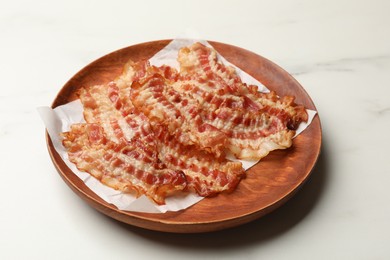 Delicious fried bacon slices on white marble table