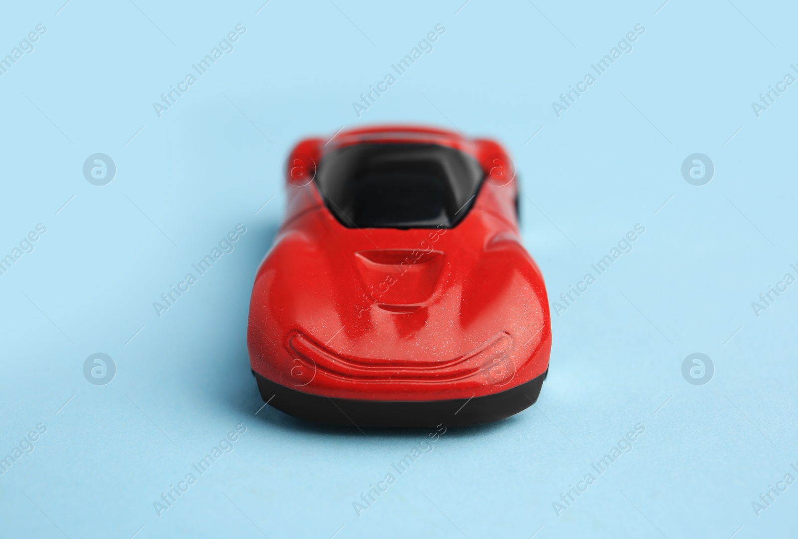 Photo of One red car on light blue background. Children`s toy